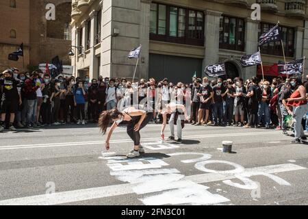 Barcelone, Espagne. 13 mai 2021. Des manifestants ont vu peindre la route pendant la manifestation.quelque 700 étudiants ont manifesté dans le centre de Barcelone à la suite de la grève organisée par les syndicats étudiants. La grève fait partie de la campagne pour que les recteurs signent l'engagement contre la crise de l'éducation, où ils demandent l'égalisation des prix des maîtresses et des diplômes et la rémunération obligatoire des stages. Crédit : SOPA Images Limited/Alamy Live News Banque D'Images