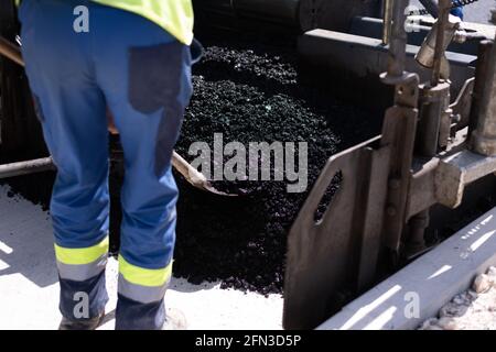 Rouleau d'asphalte lourd moderne qui empilent et presse l'asphalte chaud. Machine de réparation sur route jaune. Réparation dans une ville moderne avec un compacteur à rouleaux à vibrations Banque D'Images