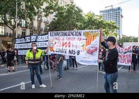 Barcelone, Espagne. 13 mai 2021. Les manifestants qui ont une bannière disant « industrialisation, Nissan défend l'emploi de 25,000 familles pendant la manifestation.quelque 800 travailleurs du constructeur automobile japonais Nissan ont manifesté devant la délégation du gouvernement espagnol à Barcelone pour demander une alternative à la fermeture de l'usine de Nissan à Barcelone, fournir également des solutions aux fournisseurs et aux entreprises sous-traitées et exiger la réindustrialisation des centres de travail concernés. Crédit : SOPA Images Limited/Alamy Live News Banque D'Images