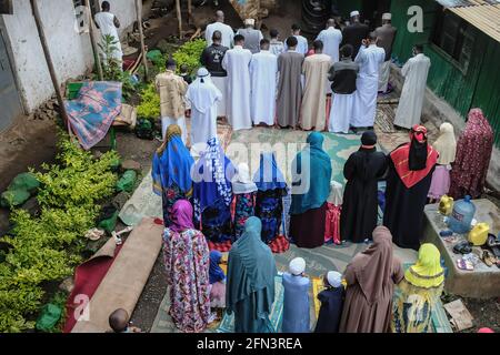 Nairobi, Kenya. 13 mai 2021. Un groupe d'hommes et de femmes musulmans propose des prières lors de la célébration d'Eid Al-Fitr à Kibera. Les frères et sœurs musulmans étaient réunis le 13 mai 2021, portant leurs masques de sécurité et leurs robes de prière colorées pendant la première journée des célébrations d'Eid Al-Fitr rompant d'un mois sacré du Ramadan le mois du jeûne et des prières au milieu de la pandémie du coronavirus. (Photo de Donwilson Odhiambo/SOPA Images/Sipa USA) crédit: SIPA USA/Alay Live News Banque D'Images