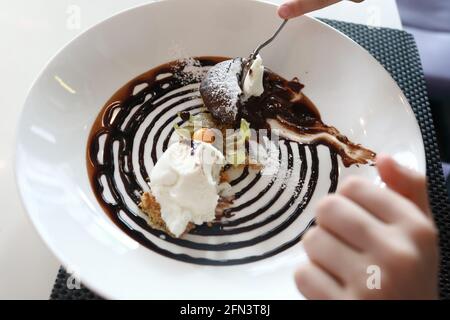 Personne mangeant du chocolat dans un restaurant Banque D'Images