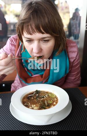 Femme mangeant de la soupe Miso dans un restaurant Banque D'Images