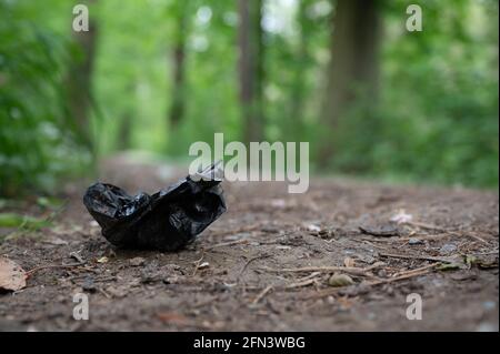 Stockstadt am Rhein, Allemagne. 13 mai 2021. Un sac en plastique noir avec excréments de chien se trouve dans le parc naturel Kühkopf-Knoblochsaue. (À dpa 'sur le comportement des excursions dans la deuxième année de la pandémie') Credit: Sebastian Gollnow/dpa/Alamy Live News Banque D'Images