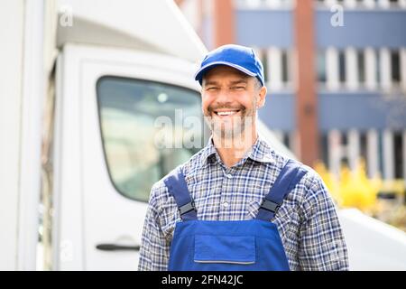 Un technicien de maintenance satisfait dans l'ensemble près d'une fourgonnette ou d'un camion Banque D'Images