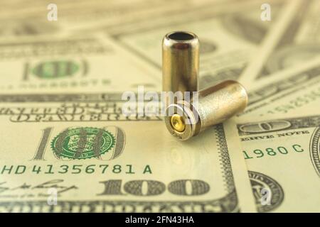 Vente illégale, concept d'argent criminel, dollars américains et balle pour une arme à feu, cartouches de pistolet de 9 mm sur un fond Banque D'Images