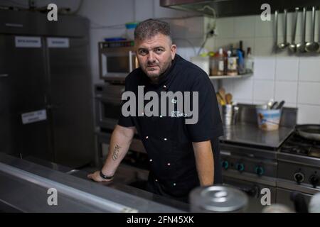 Milos, Grèce. 13 mai 2021. Papikinos Vasilis, chef de 46 ans, prend des photos dans la cuisine de son restaurant Alevromilos. Sur l'île de Milos, par exemple, et sur d'autres îles grecques, des taux de vaccination allant jusqu'à 90 pour cent pourraient être atteints dans les semaines à venir - notamment parce que les gens vivent du tourisme. Credit: Socrates Baltagiannis/dpa/Alay Live News Banque D'Images