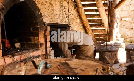 Un forgeron dans un atelier authentique. Blacksmithing dans le village. Banque D'Images