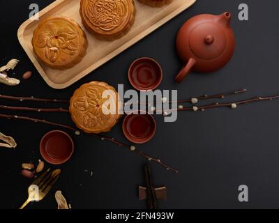 Vue de dessus de la table avec gâteaux de lune traditionnels, set de thé, décoration et espace de copie. Le caractère chinois sur le gâteau de lune représente 'cinq noyau a Banque D'Images