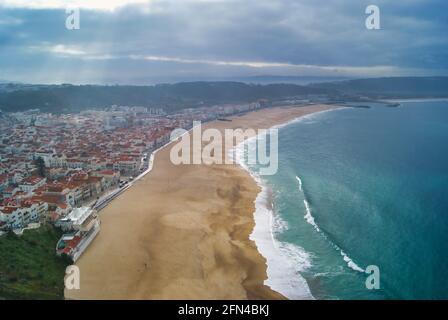 Plage de Nazarè, Portugal, vue de dessus. Magnifique plage portugaise par une journée nuageuse de printemps. Village de pêcheurs et pèlerinage religieux. Banque D'Images