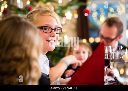 Les parents et les enfants allemands toasting avec vin et eau à dîner la veille de Noël Banque D'Images