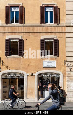 Les cyclistes passent devant les boutiques de mode de luxe de Piazza di Spagna, Rome, Italie. Banque D'Images