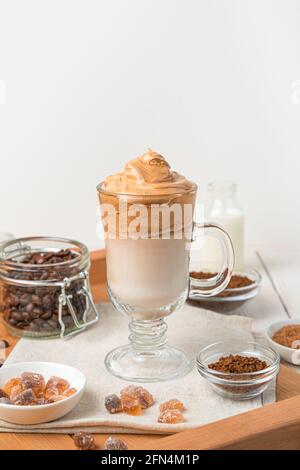 Café Dalgona avec mousse fouettée et glace sur fond blanc. Une boisson coréenne revigorante. Banque D'Images