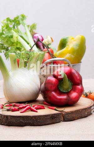 Légumes frais et divers, poivrons fenouil céleri et tomates sur une table en bois. Arrière-plan blanc. Verticale Banque D'Images