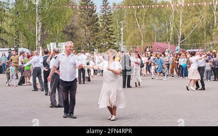 Ekaterinbourg, Russie - 9 mai 2021 : les couples seniors dansent dans le parc de printemps de la ville. Banque D'Images