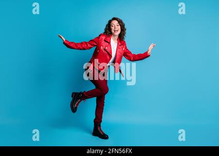 Pleine photo de fille optimiste danse porter veste rouge chaussures de pantalon isolées sur fond bleu Banque D'Images