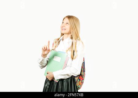 Gros plan de la jeune fille adolescente très heureuse, souriant large, dents parfaites, debout sur un fond blanc regardant pointer vers le haut avec l'inde Banque D'Images