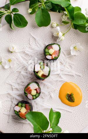 Vue de dessus d'un petit sushi japonais sain sans riz avec de la viande de crabe enveloppée de radis daikon Banque D'Images