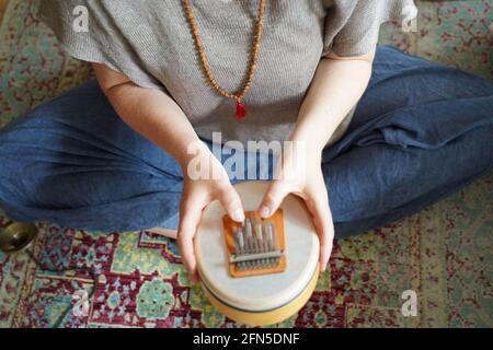 Femme tenant et jouant un instrument de guérison sonore Sansula pour la thérapie de guérison sonore Banque D'Images