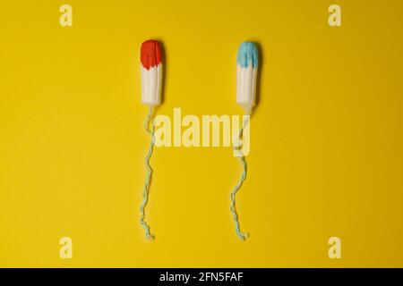 Tampons imbibés de liquide bleu et rouge comme concept de la vérité féminine inconfortable affichée irréelle dans les publicités pour les produits de mentraration Banque D'Images