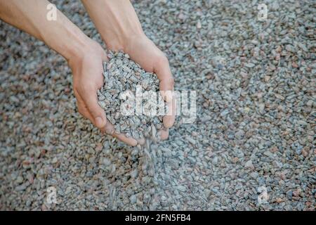 Homme tenant de petits gravats dans ses mains Banque D'Images