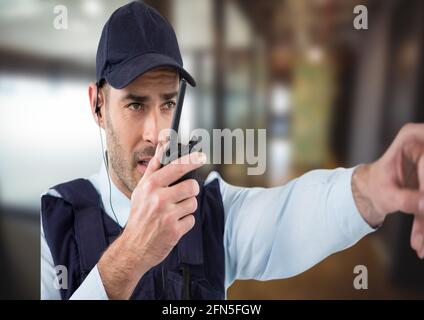 Composition d'un agent de sécurité mâle utilisant la main de main de talkie walkie sur un arrière-plan flou Banque D'Images