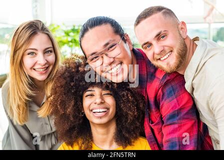 Groupe multiethnique d'amis qui prennent le selfie à l'intérieur avec une femme maurique en premier plan. Deux jeunes femmes et deux hommes en été. Personnes qui prennent le autoportrait Banque D'Images