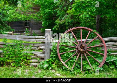 Roue de chariot à rayons en bois à gauche sur la clôture en bois une ferme Banque D'Images
