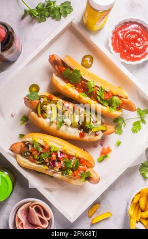 Hot dogs avec différentes garnitures épicées, vue du dessus Banque D'Images