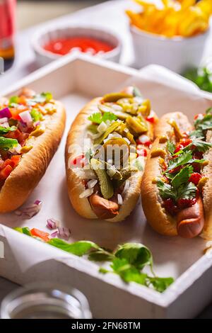 Hot dogs avec différentes garnitures épicées, gros plan Banque D'Images