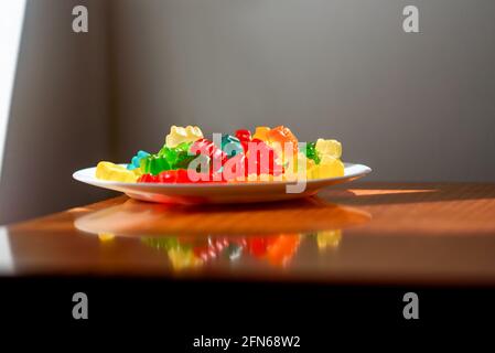 Style Still Life of Gummy Bears sur la table avec lumière directionnelle vive. Banque D'Images