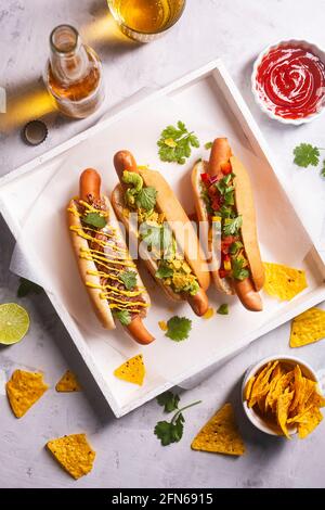 Hot dogs avec différentes garnitures épicées et nachos mexicains, bière. Vue de dessus Banque D'Images