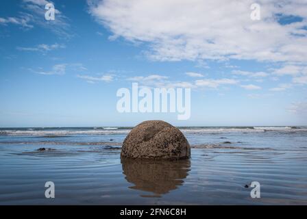 Un des Boudders de Moeraki dans la zone de surf de Koekohe Beach sur l'île du Sud de la Nouvelle-Zélande. Banque D'Images