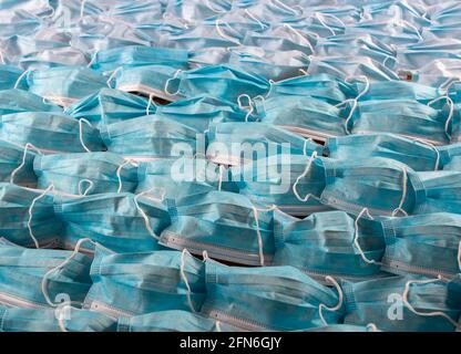 Groupe de masques chirurgicaux ouverts et utilisés disposés sur une surface plane. Métaphore des vagues sur la mer, concept des vacances d'été et du tourisme en période de pandémie Banque D'Images