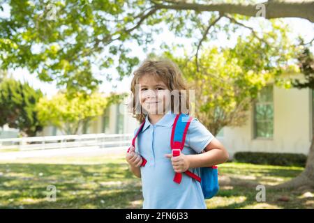 Enfant avec sac à dos pour aller à l'école. Concept d'éducation des enfants. Enfant avec sacs à dos debout dans le parc près de l'école. Élèves avec livres et sacs à dos Banque D'Images