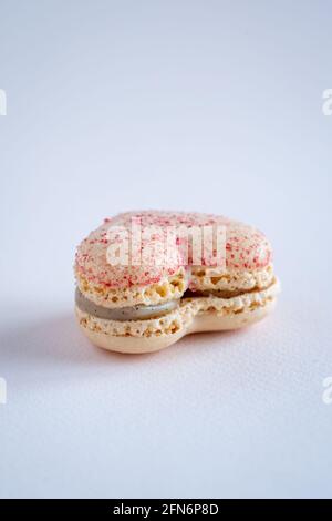 Un seul macaron français en forme de coeur, à saveur de vanille, un espace de copie sur fond neutre, vertical Banque D'Images