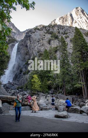 Les visiteurs apprécient leur temps et prennent des photos aux chutes de Lower Yosemite dans le parc national de Yosemite, en Californie.