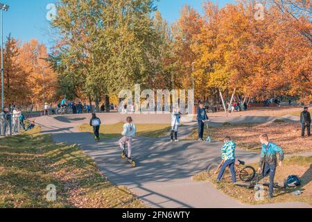 Kazan, Russie - 03 octobre 2020 : les enfants et les adolescents passent des scooters et des vélos dans le parc public de la ville d'automne Banque D'Images