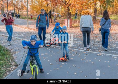 Kazan, Russie - le 03 octobre 2020 : les enfants et les adolescents passent des scooters et des vélos dans le parc public de la ville par une journée ensoleillée en automne Banque D'Images