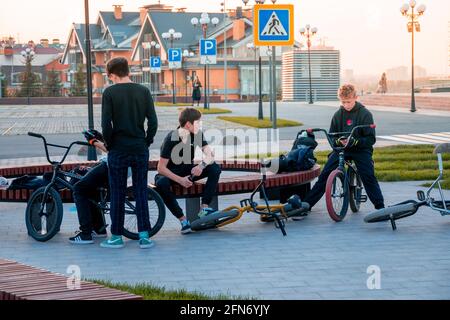 Kazan, Russie - 03 octobre 2020 : un groupe d'adolescents se détendent dans un parc de la ville à côté de leurs vélos au coucher du soleil Banque D'Images