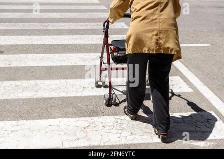 Roller poussé par une femme âgée avec des difficultés de mobilité, méconnaissable avec l'espace de copie. Banque D'Images