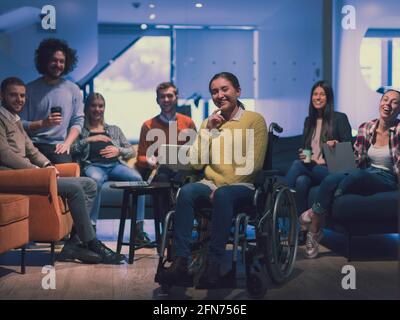 Portrait d'une femme d'affaires handicapée en fauteuil roulant devant son équipe professionnelle diversifiée au bureau Banque D'Images