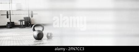 Composition de kettlebell sur le sol de la salle de sport avec lumière grise floue Banque D'Images