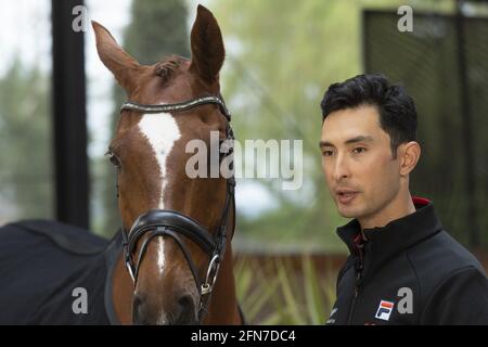 Cheshire, Grande-Bretagne. 14 mai 2021. Alex Hua Tian se tient à côté de son cheval 'Donn' lors d'une conférence de presse à Cheshire, en Grande-Bretagne, le 14 mai 2021. Le premier pilote olympique chinois Alex Hua Tian a dévoilé son nouveau slogan « Hoof Print to Tokyo » pour les Jeux Olympiques lors de la conférence de presse des écuries Pinfold à Cheshire, en Grande-Bretagne. Credit: Ray Tang/Xinhua/Alay Live News Banque D'Images