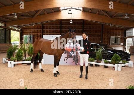 Cheshire, Grande-Bretagne. 14 mai 2021. Alex Hua Tian pose avec son cheval 'brochet' lors d'une conférence de presse à Cheshire, en Grande-Bretagne, le 14 mai 2021. Le premier pilote olympique chinois Alex Hua Tian a dévoilé son nouveau slogan « Hoof Print to Tokyo » pour les Jeux Olympiques lors de la conférence de presse des écuries Pinfold à Cheshire, en Grande-Bretagne. Credit: Ray Tang/Xinhua/Alay Live News Banque D'Images