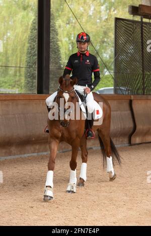 Cheshire, Grande-Bretagne. 14 mai 2021. Alex Hua Tian conduit son cheval « Don » lors d'une conférence de presse à Cheshire, en Grande-Bretagne, le 14 mai 2021. Le premier pilote olympique chinois Alex Hua Tian a dévoilé son nouveau slogan « Hoof Print to Tokyo » pour les Jeux Olympiques lors de la conférence de presse des écuries Pinfold à Cheshire, en Grande-Bretagne. Credit: Ray Tang/Xinhua/Alay Live News Banque D'Images