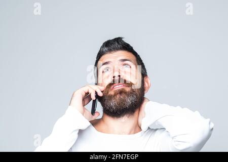 Homme barbu parlant au téléphone. Communications. Banque D'Images