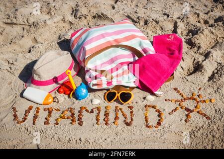 Inscription vitamine D avec forme de soleil, accessoires pour la détente et les enfants jouant sur le sable à la plage. Prévention de la carence en vitamine D. lif sain Banque D'Images