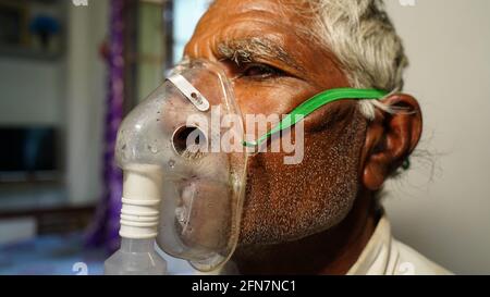 03 mai 2021 - Reengus, Sikar, Inde. Vieil Indien infecté par la maladie de Covid 19. Patient inhalant de l'oxygène porter un masque avec un flux d'oxygène liquide. Banque D'Images