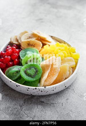 Bol avec divers fruits séchés sur fond de béton gris Banque D'Images