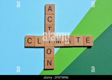 Climate action, mots en lettres de l'alphabet en bois en forme de mots croisés isolés sur fond bleu vert Banque D'Images